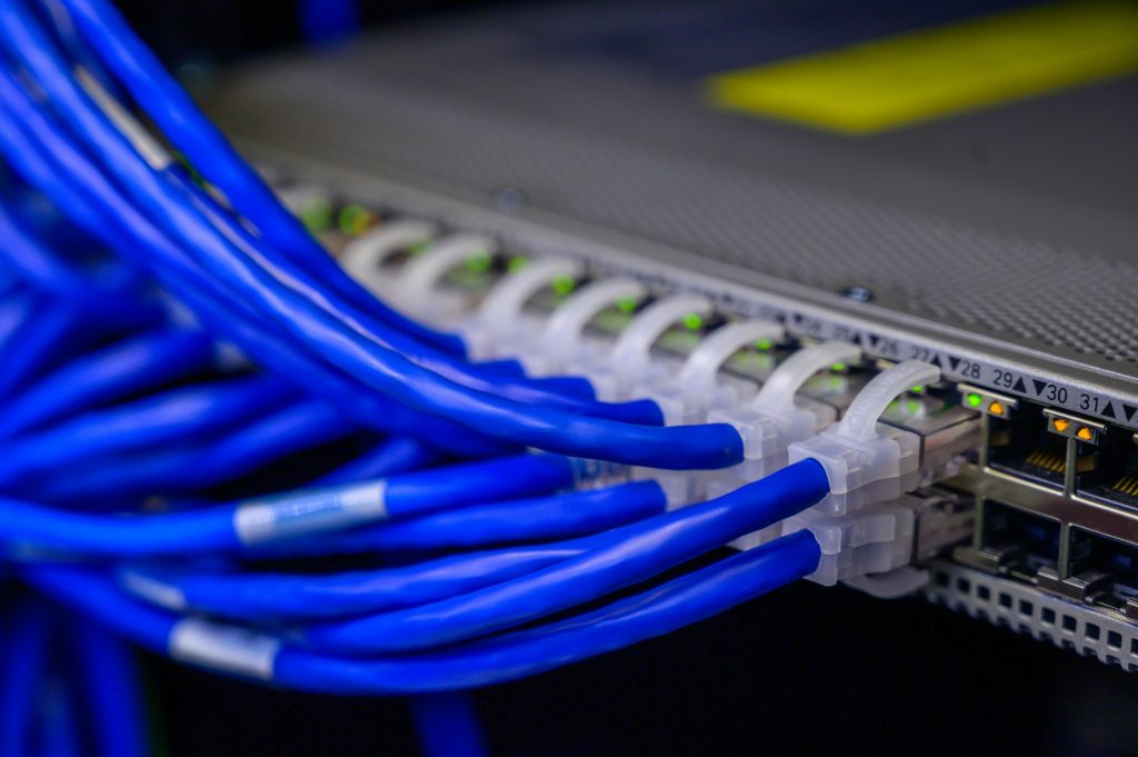 pexels-photo-2881232-2881232 Detailed view of blue ethernet cables connected to a network switch in a data center.